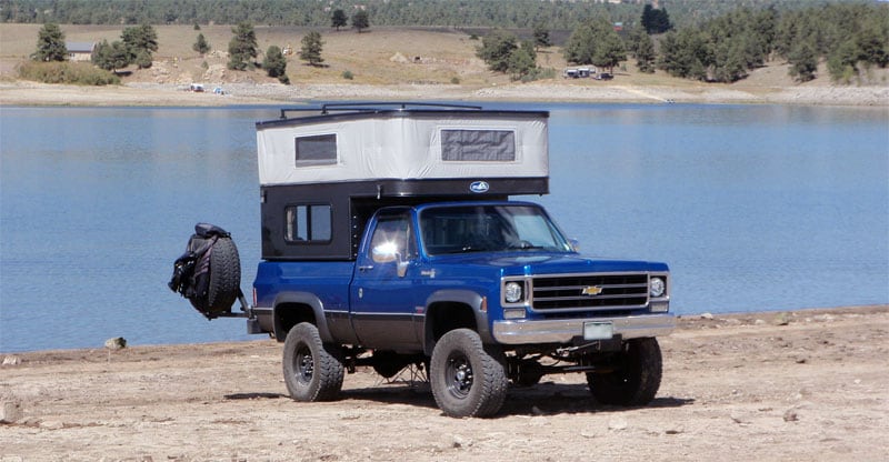 Camper Backed Up To Lake Relaxing