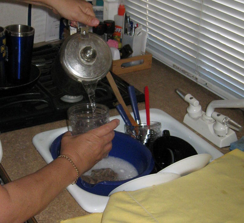 Pouring Hot Water from Stove Top For Dishes