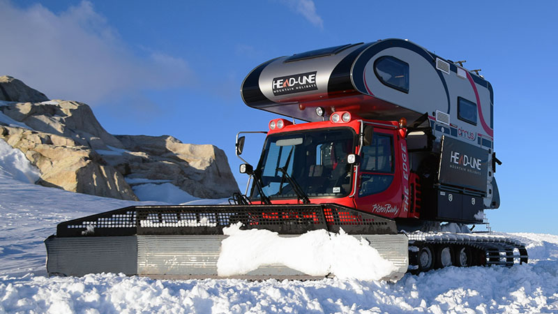 Snowcat truck camper pushing snow