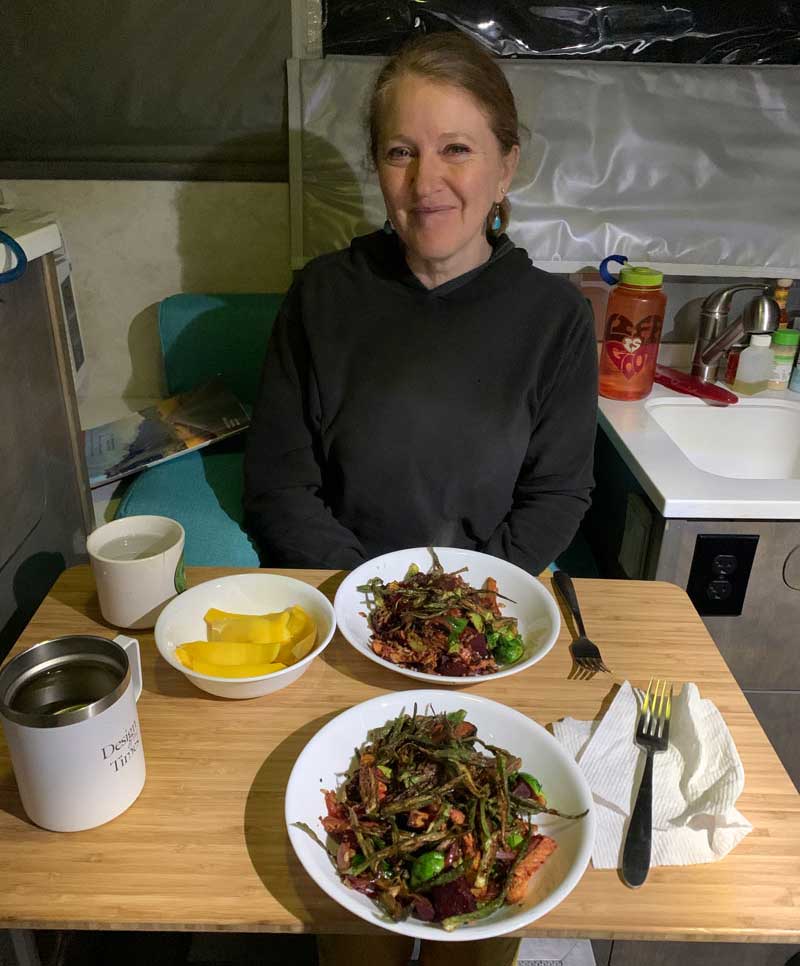 Jeanne having dinner in camper dinette