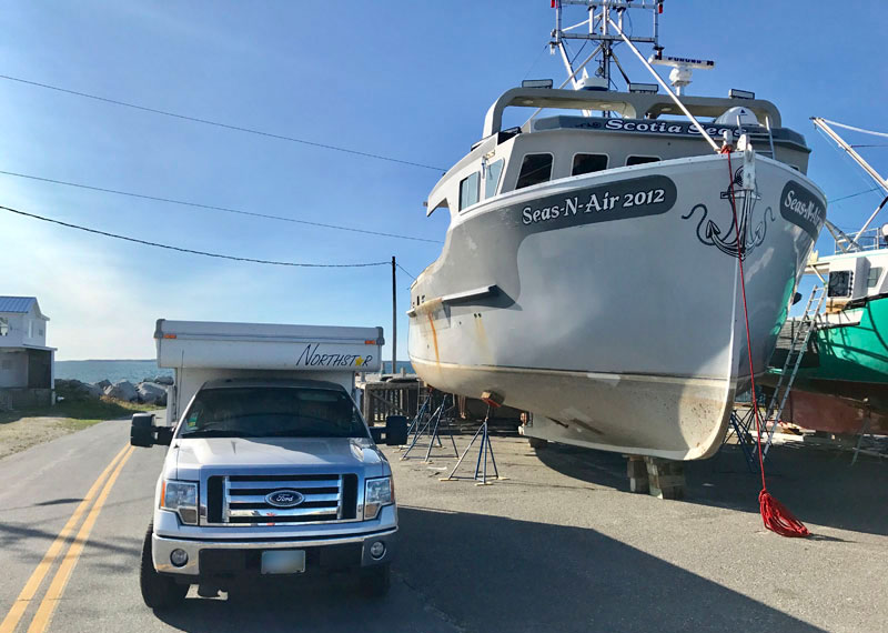 Camper Seems Small Next To A Local Fishing Boat