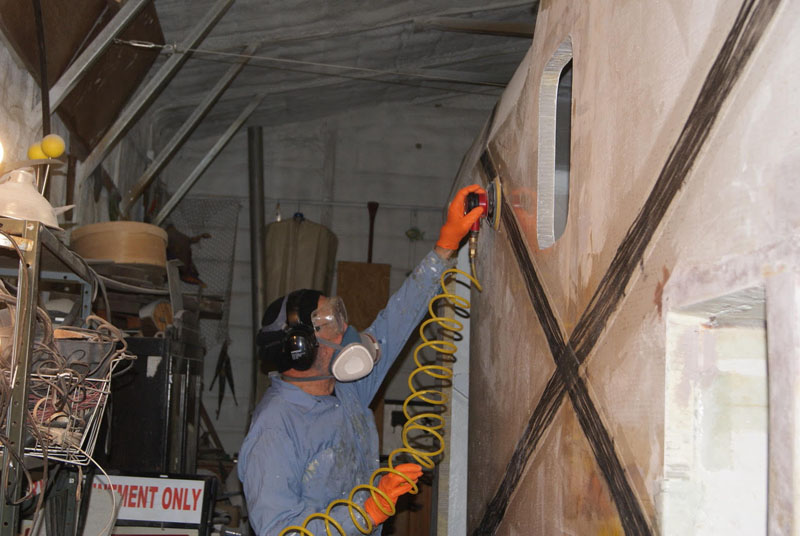 Tom sanding the side of the camper