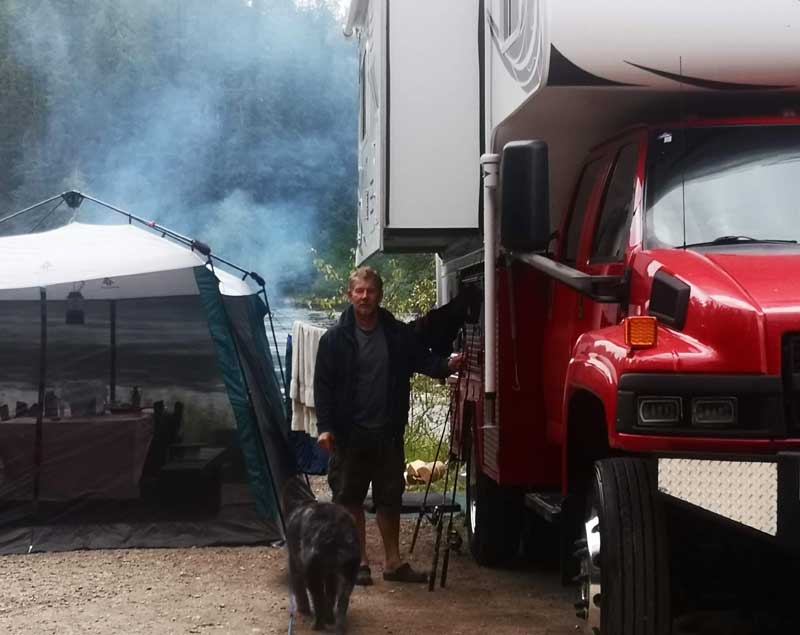 Ralf Standing Under Slide Out While Camper On Kodiak