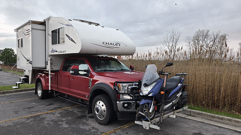 Scooter On Front of Chalet and Ford rig