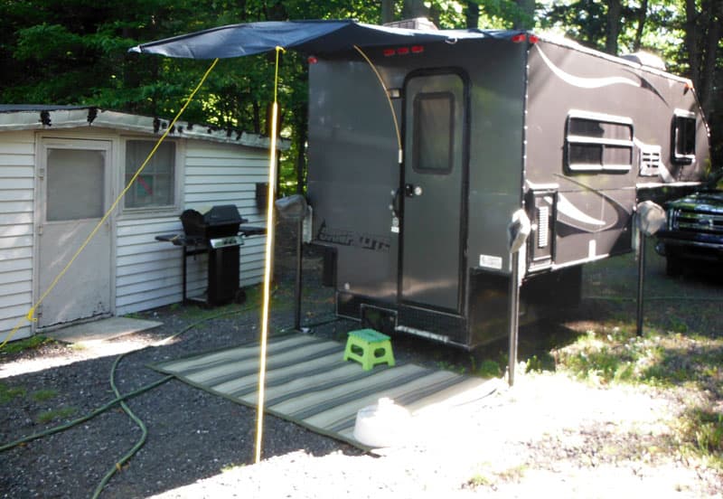 Awning attached to camper roof with two brackets