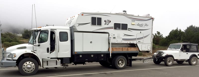 Freightliner truck camping towing a Jeep