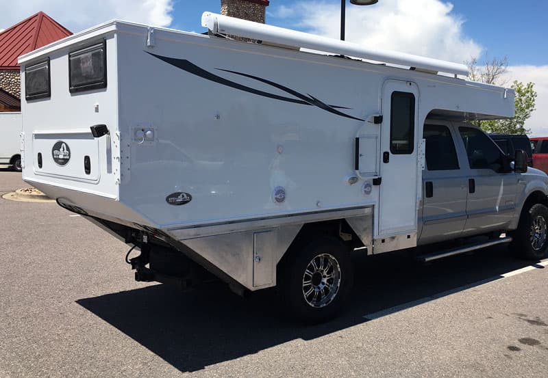 Forward drop entry door to truck camper