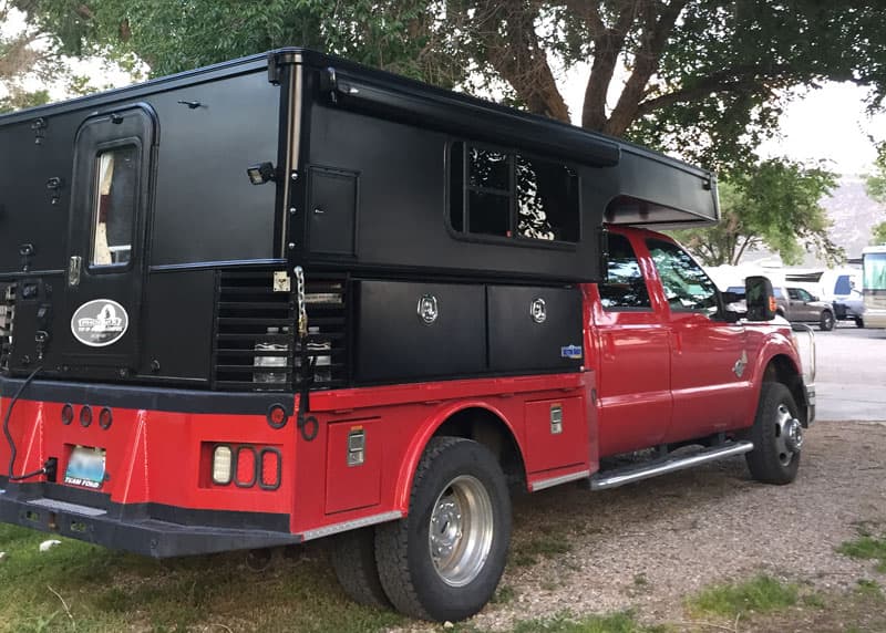 Black truck camper and red truck