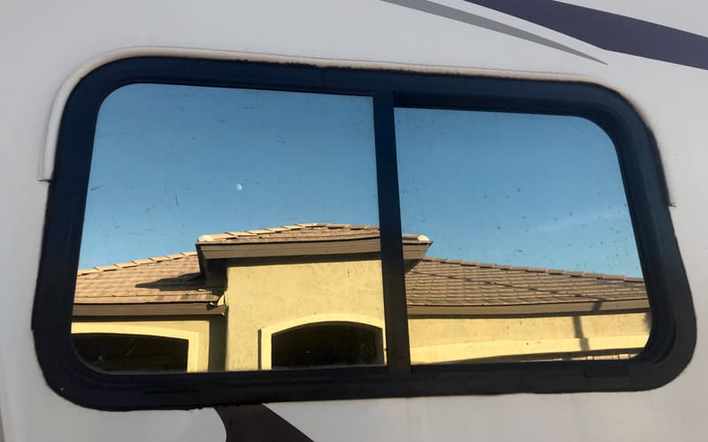 Stick on gutters over camper window to divert the rain water