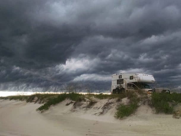 #220 - Pete Mather and Jean ClarksonDavis Island, North Carolina1999 Ford F2501998 Northstar 8.5 AdventurerCamera Used - Driod phoneJuly squalls are so lovely to watch, and that's why they call it Cape Lookout!  We were headed north to spend our last night out of five on the island up around the ferry landing.  After leaving the light house, we drove for 20 minutes or so, when I looked in my mirror and saw that storm front closing in fast.  When I said, 