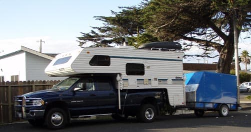 Truck camper towing trailer